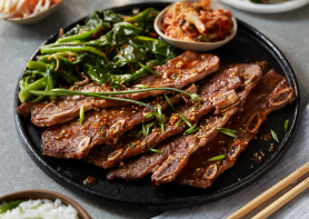 plated flanked dino ribs with greens and a side of kimchi