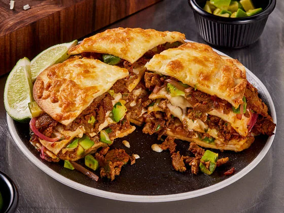 Philly birria steak pizza torta with lime on the side