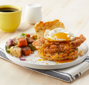 Chicken biscuit breakfast sandwich with egg and a side of veggies