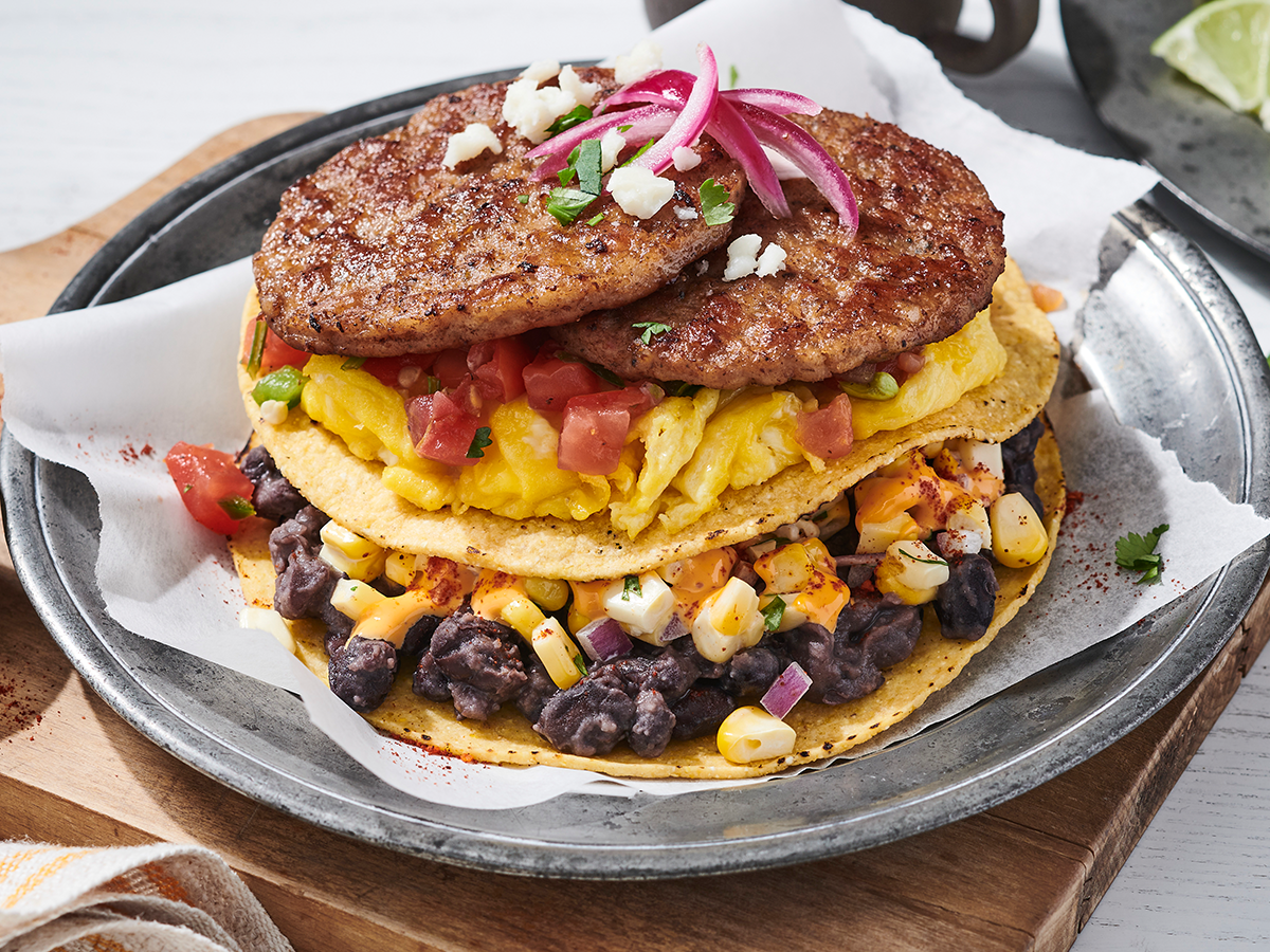 Stacked breakfast tostadas with sausage, eggs, corn and black beans