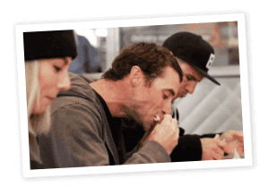 Man eating sandwich with gray hoodie 