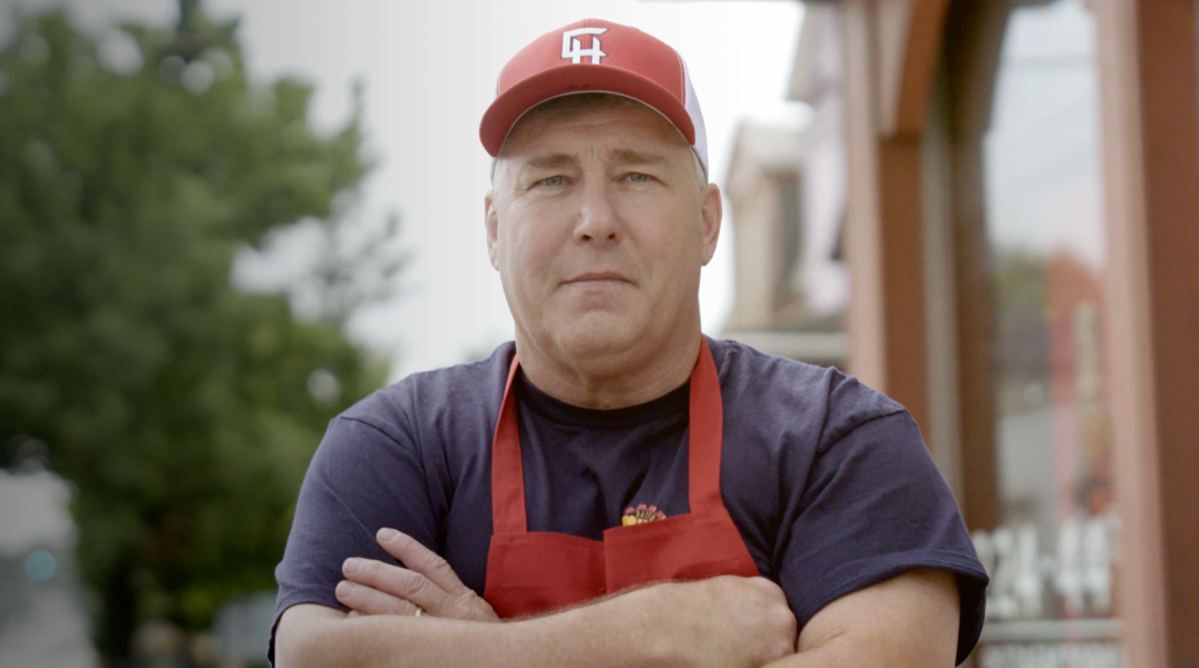 2023 Great Pizza Give Back winner owner with red hat and apron, crossing hands