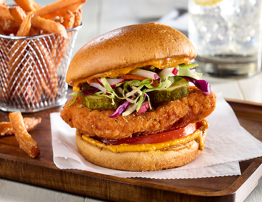 Chicken sandwich with pickles and slaw, with a side of fries